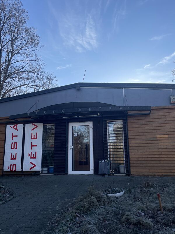 Vstup do budovy Šestá Větev s bannery a označením